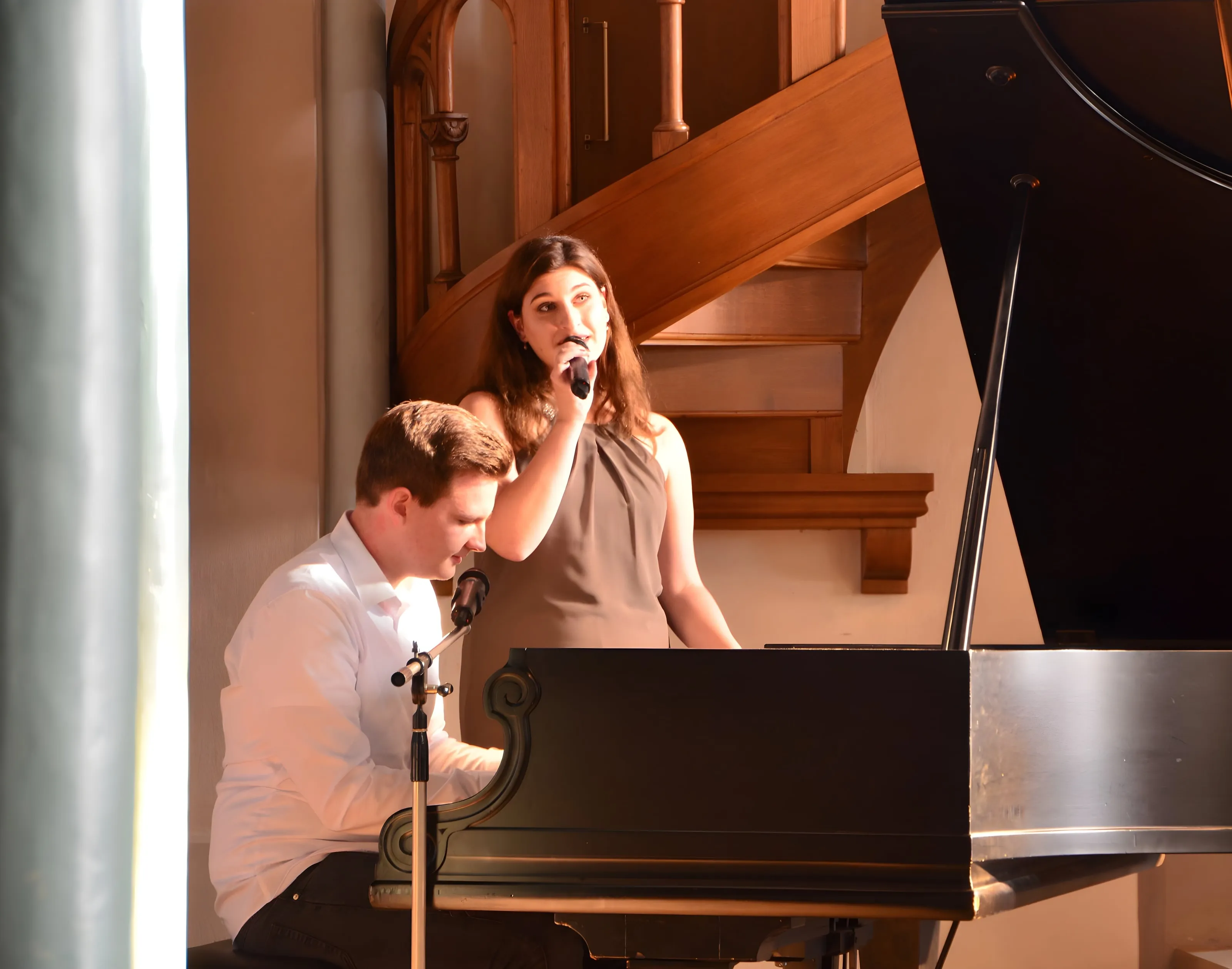 Sophia singt am Mikrofon, Dominik begleitet sie am Flügel